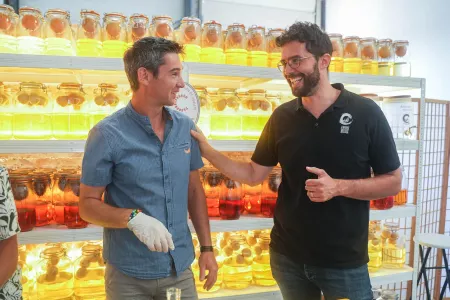 adrien rigole avec un stagiaire en lui tapotant sur l'épaule