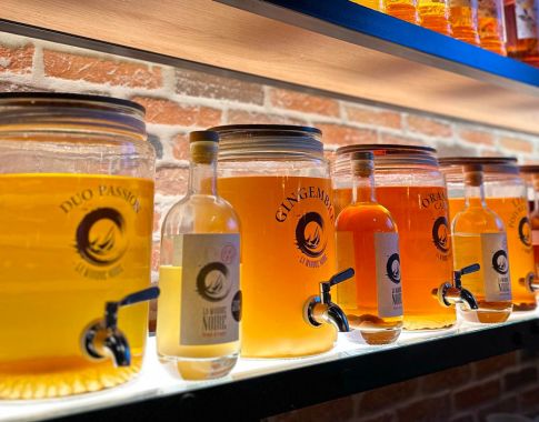plusieurs distributeurs de rhum arrangé en verre avec robinet inox alignés derrière un bar